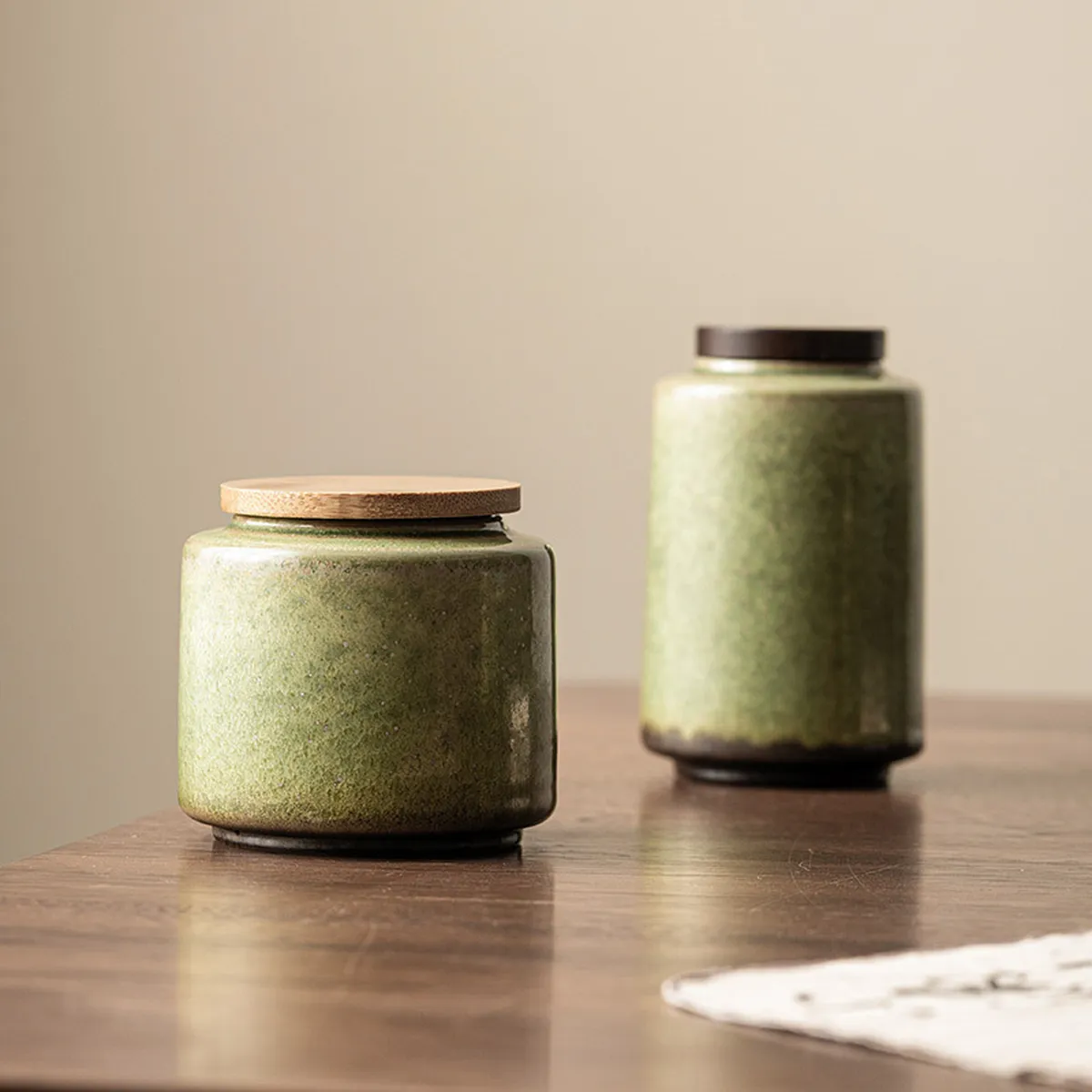 Les deux modèles de boîte à thé verte, court et haut, sur une table en bois