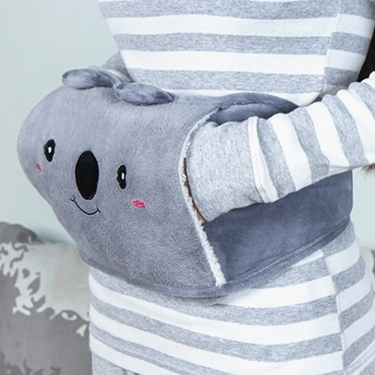 Ceinture bouillotte en polaire grise à motif koala, mains glissées dans la poche
