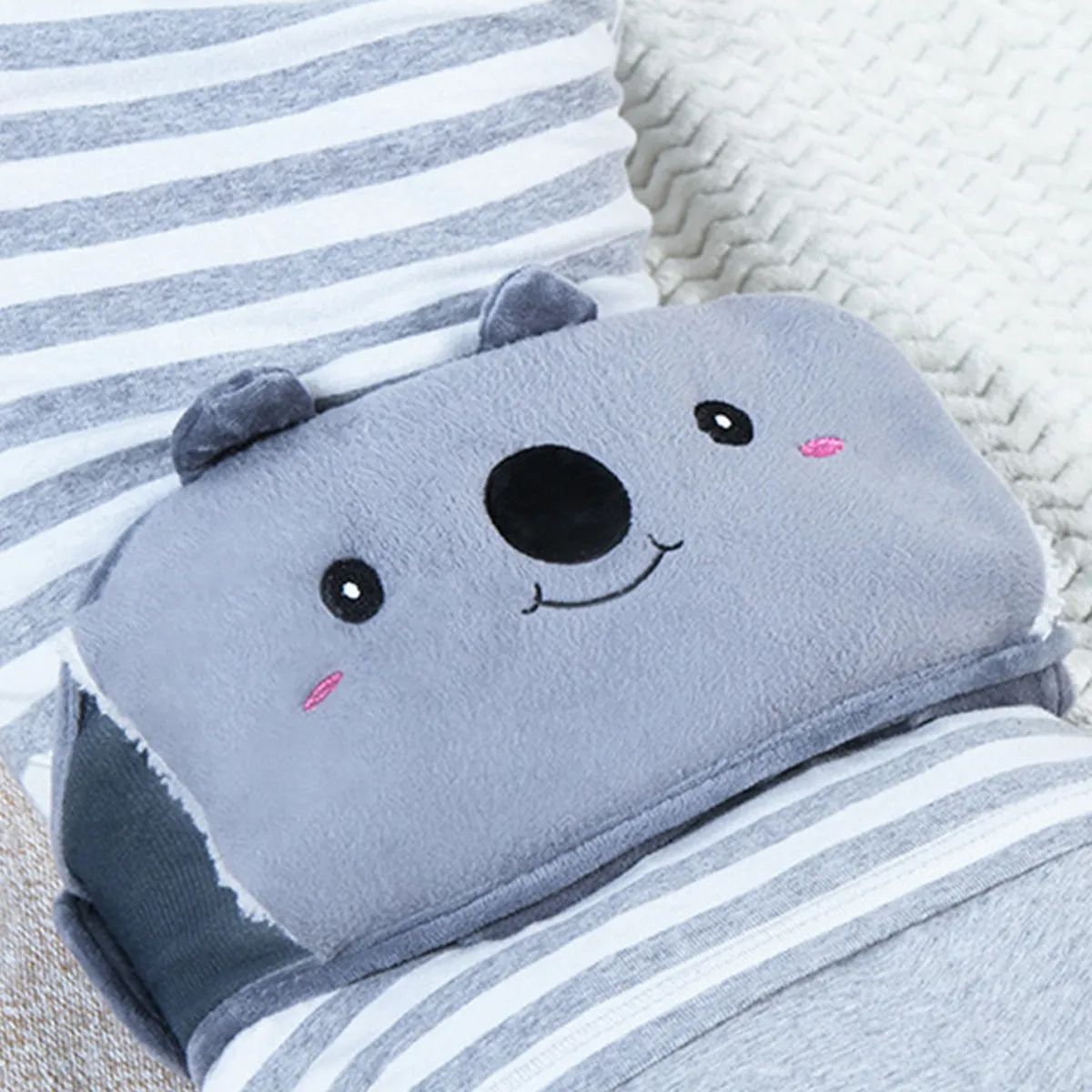 La ceinture bouillotte koala portée sur un pull rayé, sur le canapé