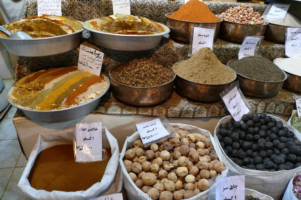 Étals d’épices en vrac dans un marché : curcuma, poivre, piments et graines