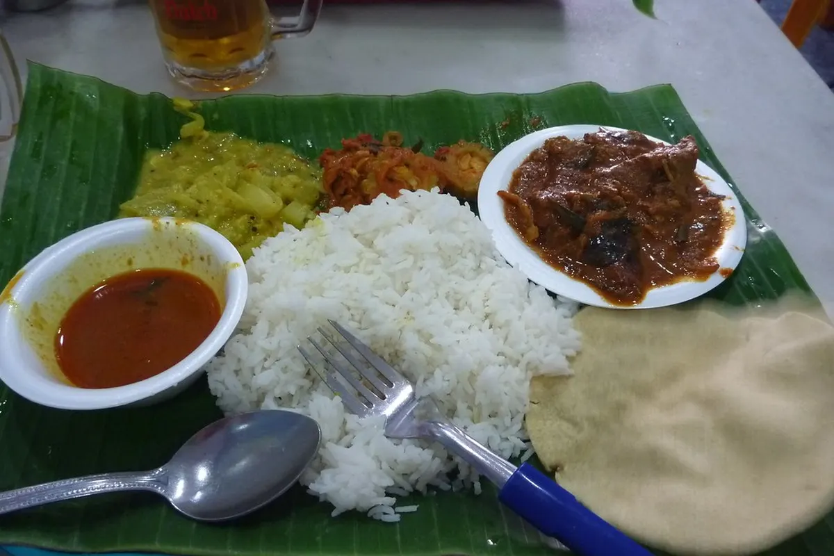 Repas indien servi sur une feuille de bananier : riz, sauces et galette